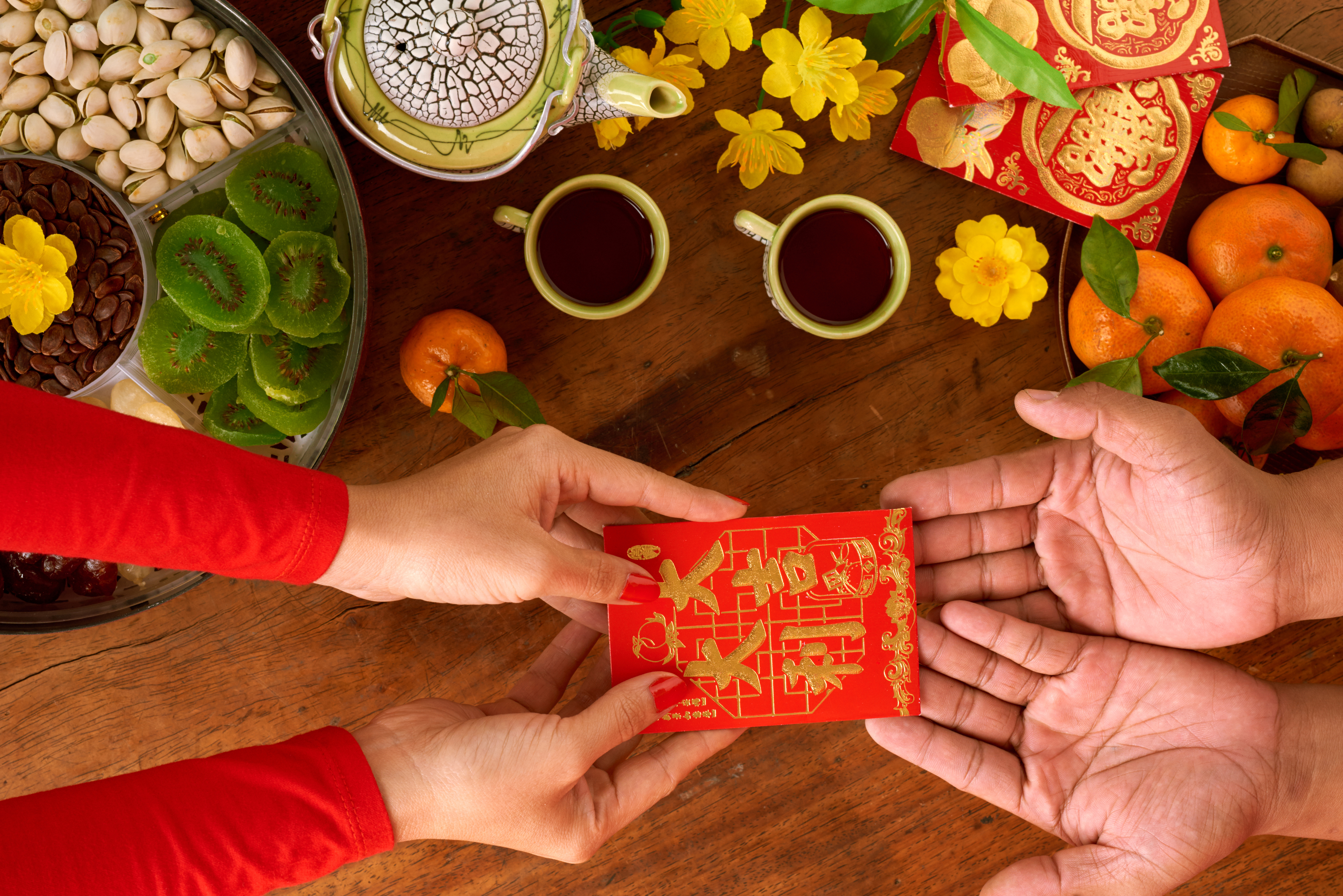 top-view-unrecognizable-cropped-woman-handing-chinese-new-year-gift-man 1